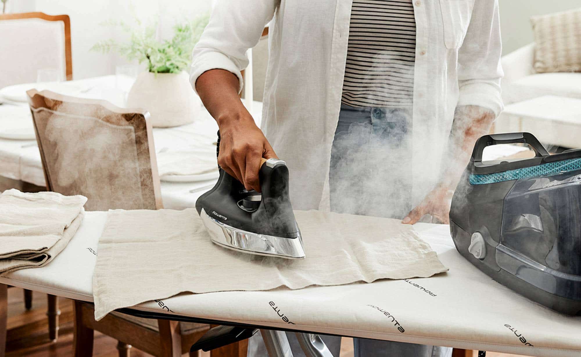 Person using a steam iron to smooth out garments.